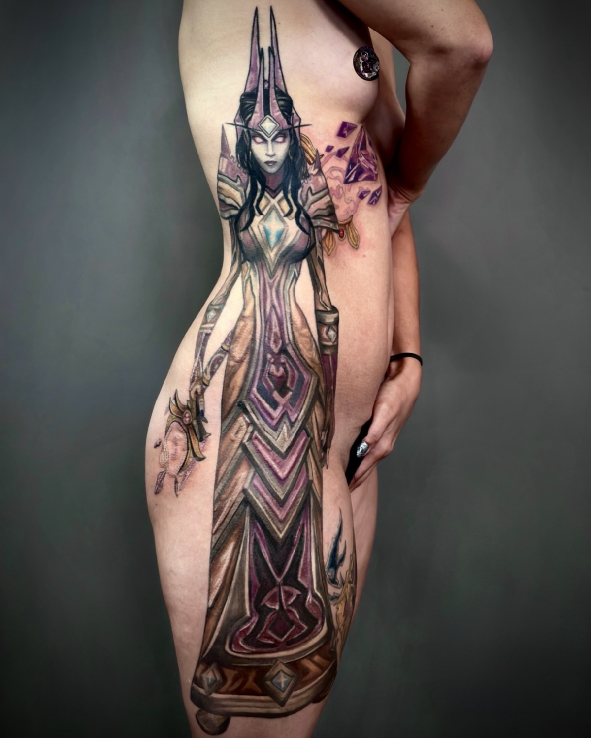 Color Tattoo Deggendorf — großflächiges Farb Tattoo einer Fantasy Hohepriesterin in lila Rüstung an Seite und Oberschenkel von Luca Limito Tattoo, Atelier Voltaire Tattoo Studio / Color tattoo Deggendorf — large fantasy high priestess in purple armor along side and thigh by Luca Limito at Atelier Voltaire Tattoo Studio