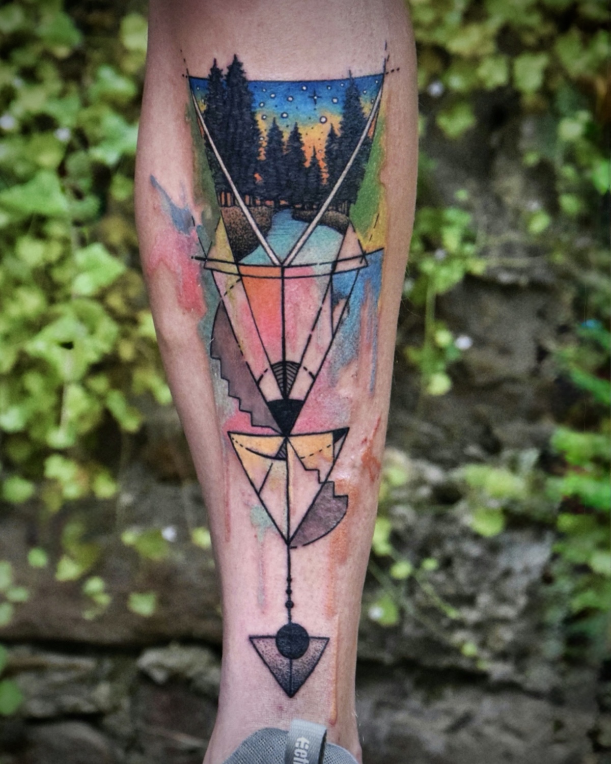 Watercolor Tattoo Deggendorf — Aquarell geometrische Waldlandschaft Unterschenkel mit Dreiecken und Sternenhimmel, Luca Limito Tattoo, Atelier Voltaire Tattoo Studio / Watercolor tattoo Deggendorf — geometric forest landscape on lower leg with triangles and starry sky by Luca Limito at Atelier Voltaire Tattoo Studio