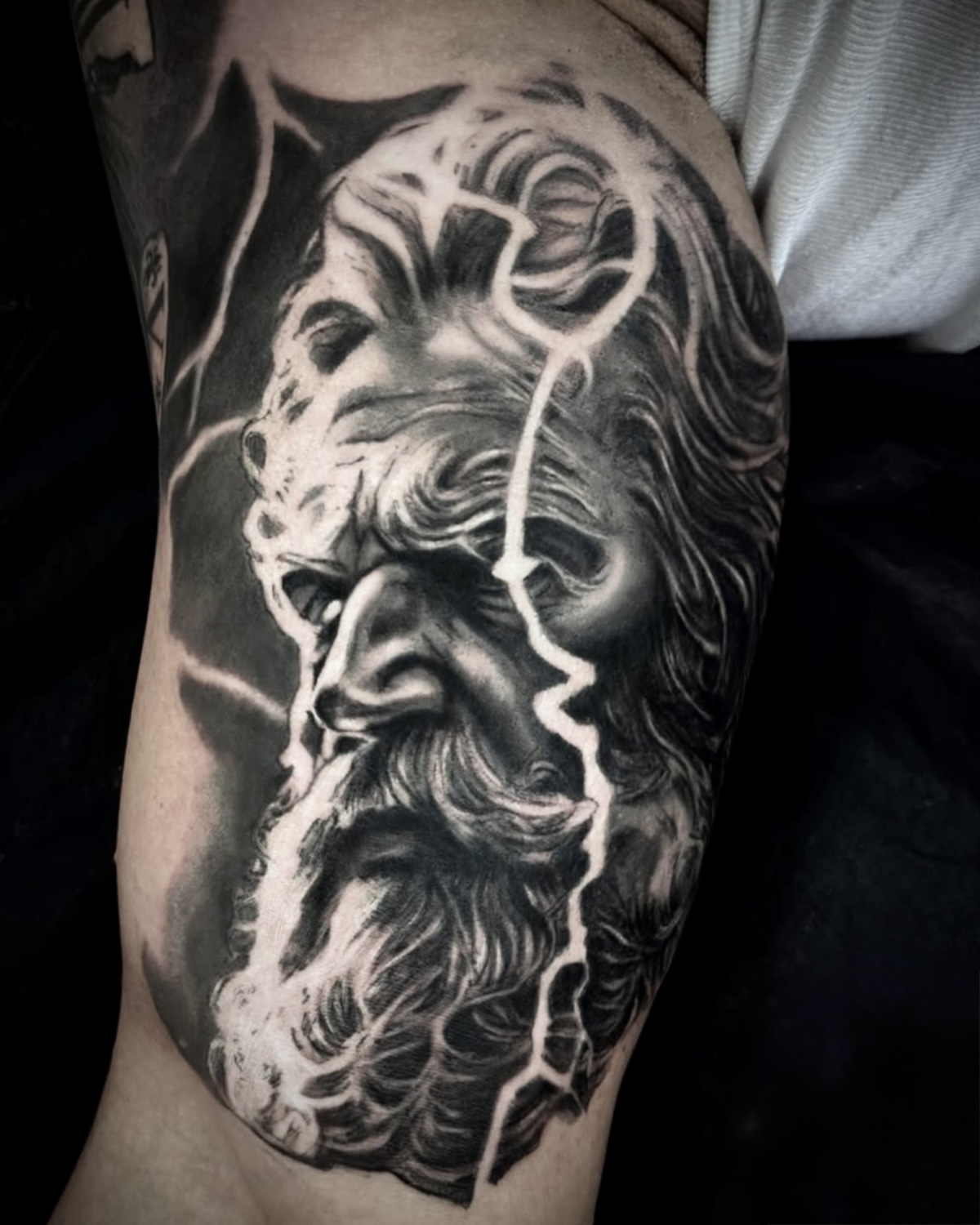 Black & Grey Tattoo Deggendorf — hyperrealistische Zeus Marmorbüste mit Blitz am Oberschenkel von Luca Limito Tattoo, Atelier Voltaire Tattoo Studio / Black and grey tattoo Deggendorf — hyperrealistic Zeus marble bust with lightning on thigh by Luca Limito at Atelier Voltaire Tattoo Studio