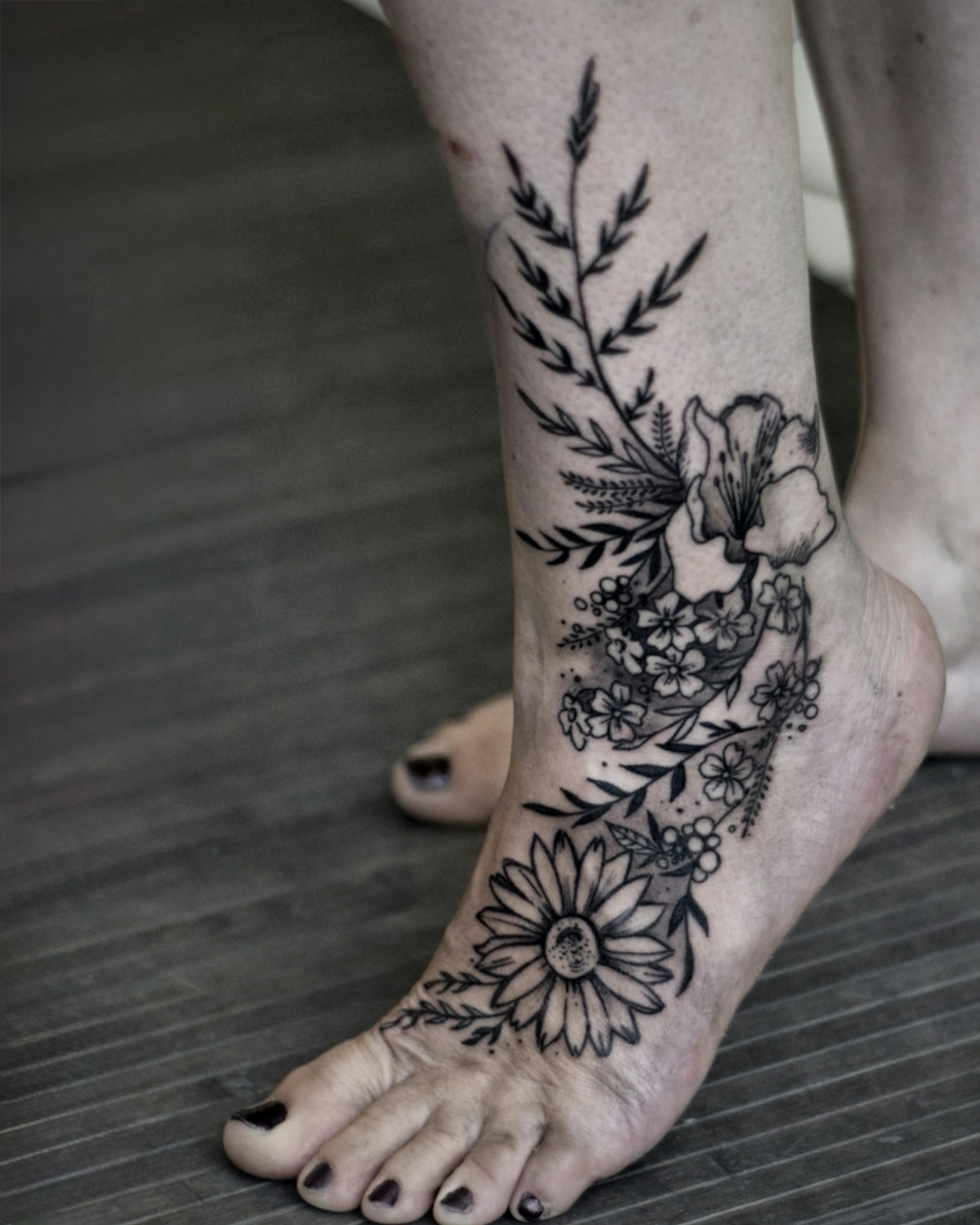 Blackwork Tattoo Deggendorf — fineline Blumen Komposition mit Margerite, Lilie und Farn am Fuß und Knöchel, Tattoo Studio Deggendorf Luca Limito Tattoo, Atelier Voltaire Tattoo Studio / Blackwork tattoo Deggendorf — fineline floral composition with daisy, lily and fern on foot and ankle by Luca Limito at Atelier Voltaire Tattoo Studio