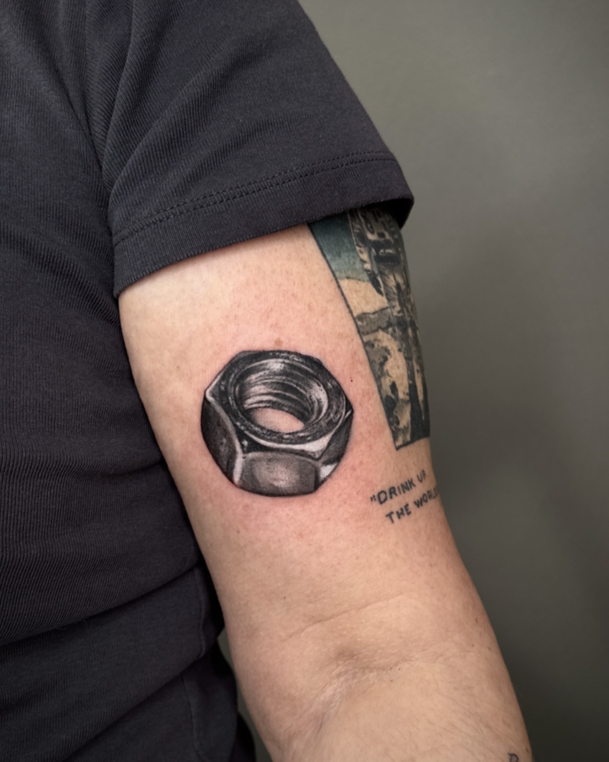 Black & Grey Tattoos Deggendorf — fotorealistische Sechskantmutter am Oberarm, Tattoo Studio Deggendorf von Luca Limito, Atelier Voltaire Tattoo Studio / Black and grey tattoos Deggendorf — photorealistic hex nut on upper arm by Luca Limito at Atelier Voltaire Tattoo Studio