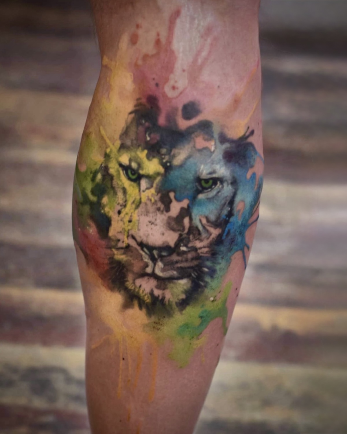 Watercolor Tattoos Deggendorf — Aquarell Löwen Portrait Wade mit fließenden Farbsplashes, Tätowierer Deggendorf Luca Limito, Atelier Voltaire Tattoo Studio / Watercolor tattoos Deggendorf — aquarelle lion portrait on calf with flowing color splashes by Luca Limito at Atelier Voltaire Tattoo Studio